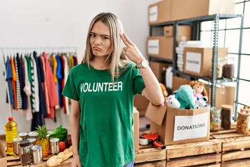 Asian young woman wearing volunteer t shirt at donations stand shooting and killing oneself...