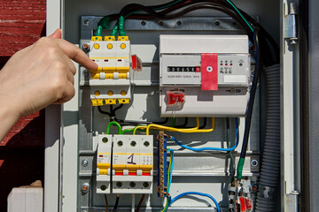 Switching circuit breaker in switchboard with electricity meter.
