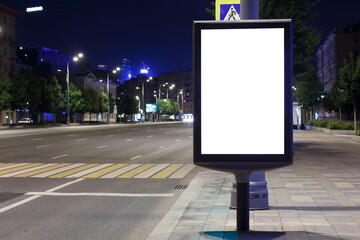 Vertical billboard advertising in the night city. Sky glows from the neon illumination of the city. Mock-up.