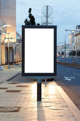 Vertical billboard advertising in the night city. In the headlights of a car. Mock-up.