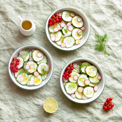 Radish and cucumber salad served in round bowls, decorated with red currants