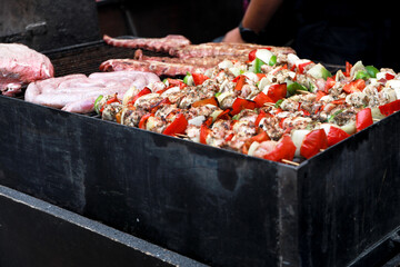 A barbecue of sausages, chops and brochettes cooking on the fire at a flea market during the fogueras festivities in Alicante.