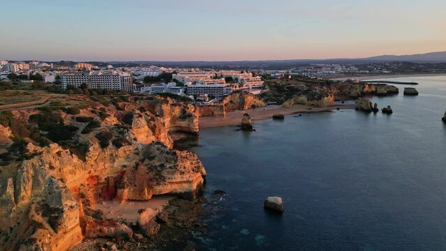 Aerial Drone Shots 4k, View of the coast and Praia de Dona Ana, Lagos, flying over the cliffs, Sunrise, Algarve, Portugal