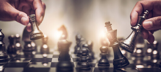 Businessman moving chess piece on chess board game concept for ideas and competition and strategy, business success concept, business competition planning teamwork strategic concept. - obrazy, fototapety, plakaty