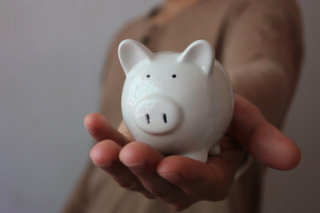 Man hand holding piggy bank, Promote saving money wealth and financial concept.