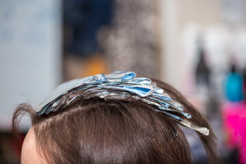 Hairdresser stylist takes care of girl's hair. Hair care procedures in a beauty salon. Hair...
