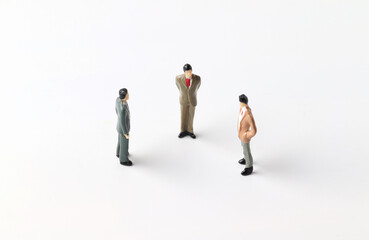 Fototapeta na wymiar Three miniature people discussing work ideas. Team work concept.