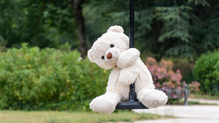 White teddy bear, doing the zip line, in the middle of nature