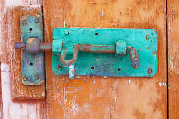Old lock on the red door of an old farmhouse