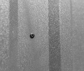Close-up of a rivet in a profiled sheet. The method of fastening the profiled sheet.