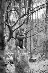 Wood carved squirrel in a forest at an adventure trail in Freising, Germany. Monochrom
