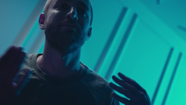 A music producer is dancing in a music studio. A man on drugs. Electonic music.