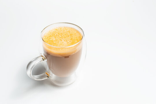 Double walled glass mug with coffee and vegan milk on white background.