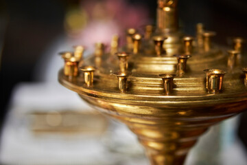 large golden candlestick in the church, soft focus. golden shackle in the temple, close-up. A large...