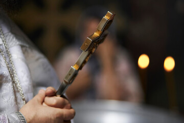 The priest of the Orthodox Church holds a golden cross. Golden cross in the hands of a priest. A...