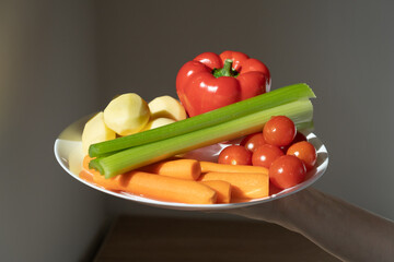 Glare from sun on colorful summer vegetables. Juicy vegetables for cooking various dishes or eating raw. Vegetarianism, raw food diet, vegan, healthy eating, vitamins in foods. Shadow in background. 