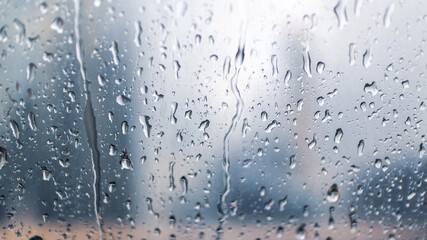Raindrops over the window with buildings of the city in the background - 513339002