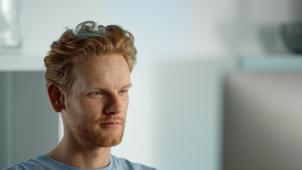 Smiling man looking computer screen closeup. Relaxed ginger guy watching blog