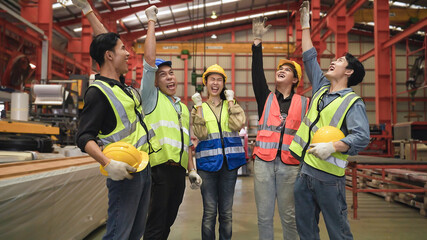 Group of Asian engineers and workers standing smiling wears safety helmet with joined stacking hand...