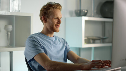 Smiling IT manager typing keyboard at closeup. Ginger man surfing internet web