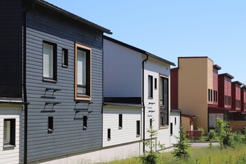 Modern colorful wooden row houses. Scandinavian architecture. Living close to the services and nature. Homes for families and couples.