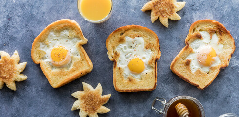 Fototapeta na wymiar Fried egg sunshine toasts surrounded by sun shapes, juice and honey.