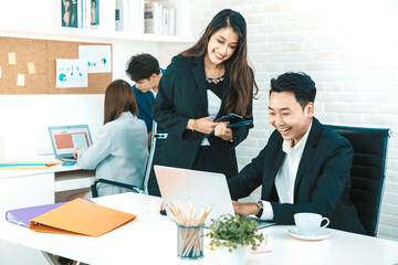 Young beautiful woman smile and discussing work with her coworker while standing at office