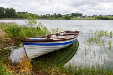 Naklejka na ściany i meble Rowing boat moored up at a lake