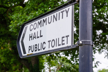 Sign to the community hall and public toilet in a rural village.
