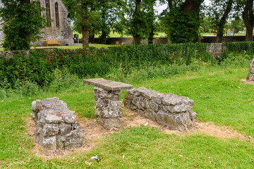 Picnic table and benches made from ancient stone in a park.