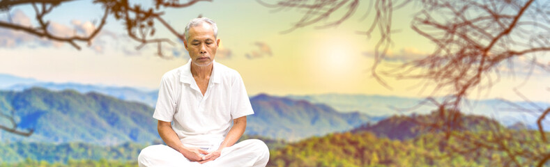 Fototapeta na wymiar Elderly man meditating on blurry nature