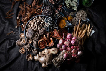 Various Thai and Chinese herbs in ceramic bowl on a dark background. Herbal and Spices Oriental...