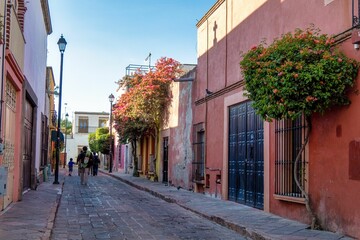Rustic street with windows and bougainvillea flowers in Queretaro, Mexico