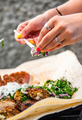 woman hand holding plastic fork with meat and sause outdoor