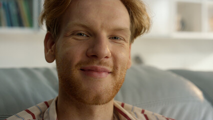 Happy businessman enjoy weekend at home closeup. Smiling ginger guy relaxing