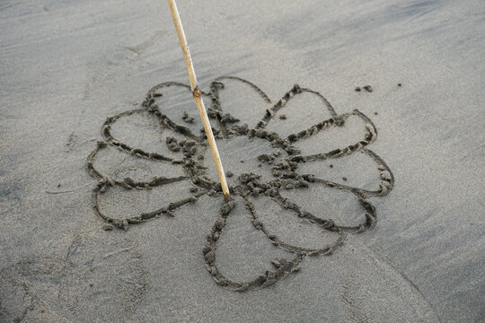 draw flower symbol on beach sand