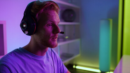 Cyber player talking headset communicating with team in neon room close up.