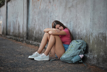 sad and lonely girl leaning against a wall