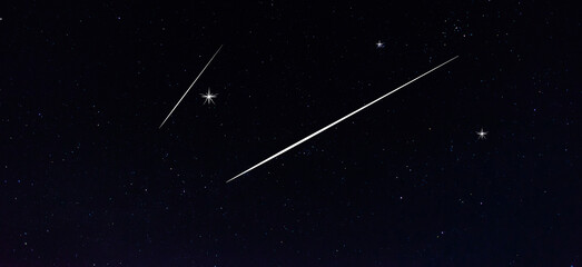 Obraz na płótnie Canvas meteorites fly in the night sky. Bright meteors glow in the atmosphere. Beautiful shooting stars.