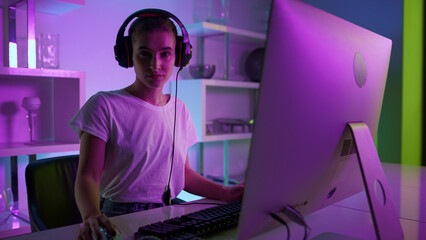 Esport gamer posing headset at neon home. Serious girl resting play video game