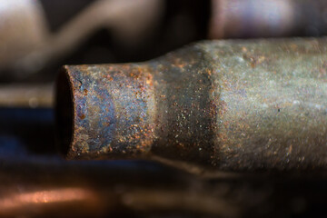 a used cartridge case from 5.45 caliber ammunition (from an AK-74 5.45 × 39mm assault rifle), rust and erosion marks are visible, macro photography