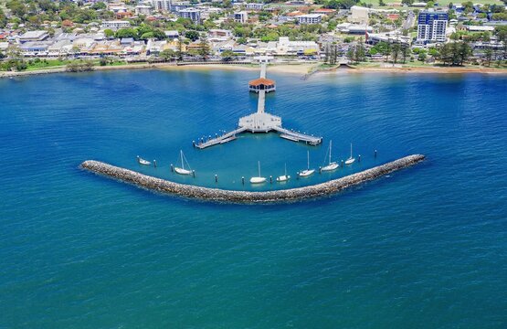 Breathtaking view of boats in the sea with buildings on the background in Redcliffe, Australia