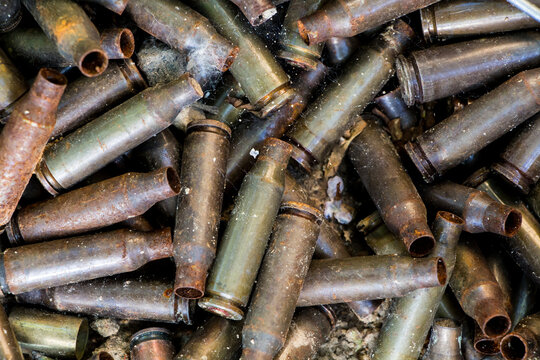 used shells from 5.45 caliber ammunition (from AK-74 5.45&times;39mm), rust and erosion marks are visible, background