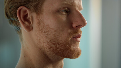 Serious man face expression closeup. Tired ginger worker resting after hard day