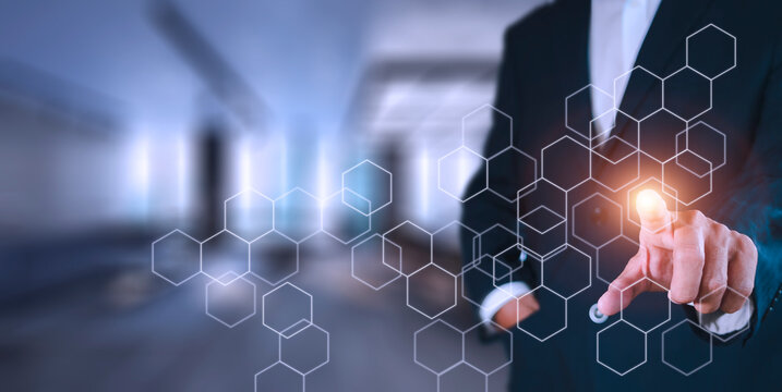 Businessman pressing button on hologram virtual screens with hexagons and transparent. Business technology internet and virtual reality concept.