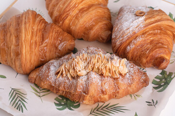 crossants. many crossants fresh baked on plate on table. cream and almond top icing