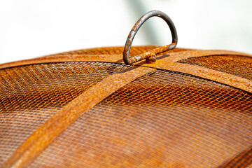 Closeup of the top of a firepit.   The mesh top is badly rusted from the weather.
