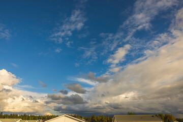 Fototapeta premium Beautiful view of blue sky with thunder clouds over roofs of village houses. Sweden.