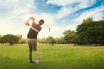 Male golf player with golf club taking a shot. - 513359201
