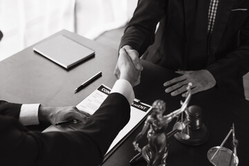 Close-up Of Two Businessmen Shaking Hands In Front Of Mallet
